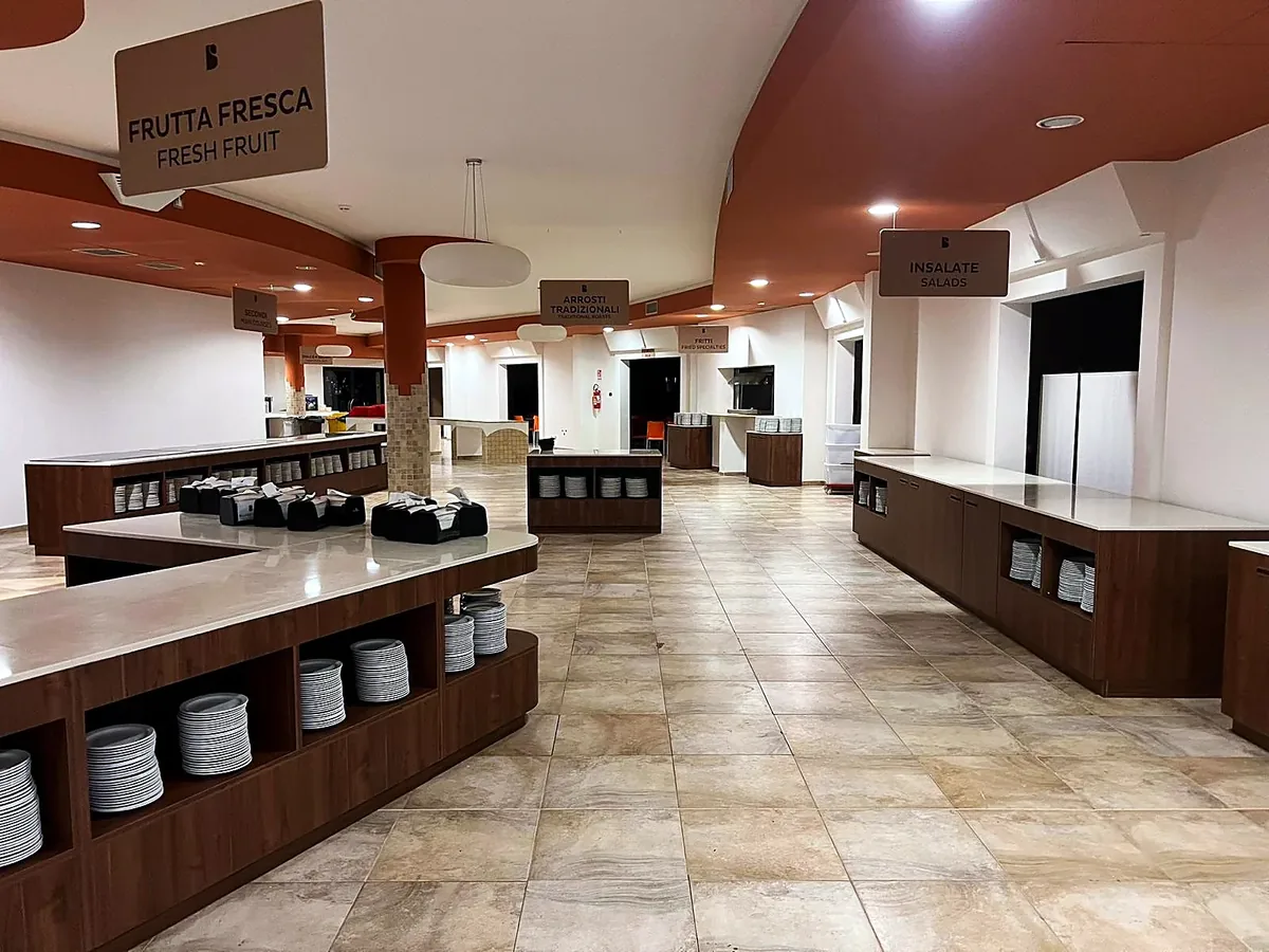 Hotel Resort in cantiere: corridoio centrale fra le isole, insegne Frutta fresca, Arrosti tradizionali e Insalate
