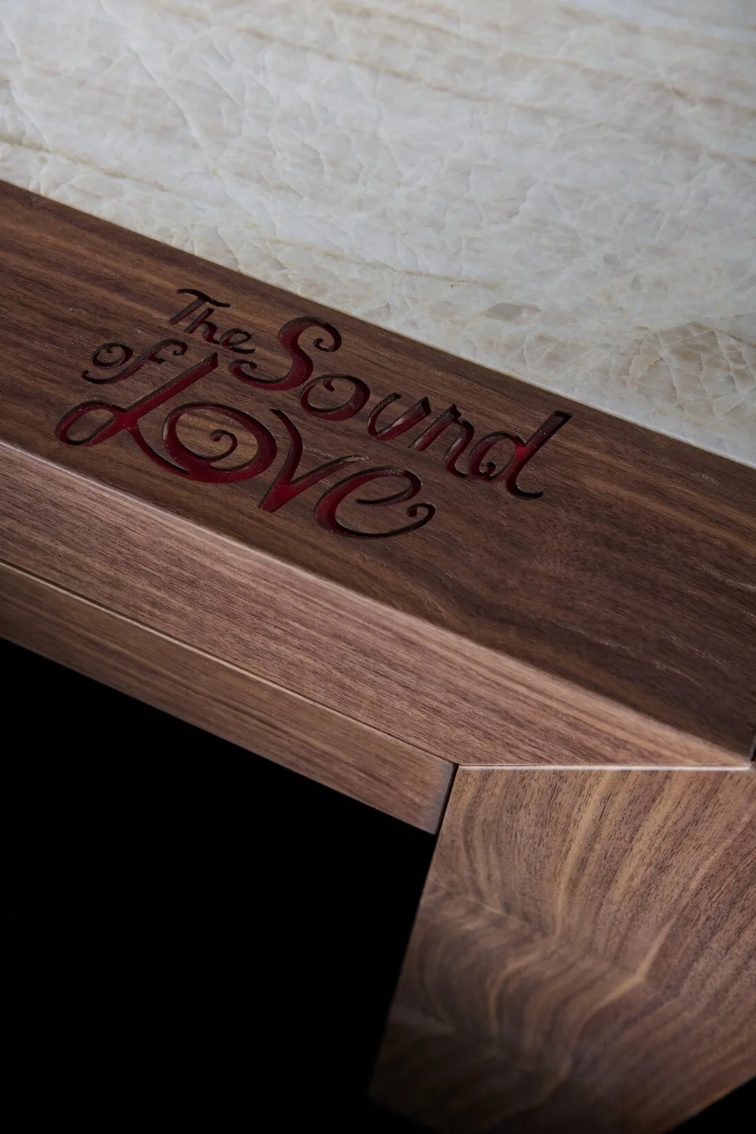 La firma The Sound of Love incisa nel noce, a luce spenta