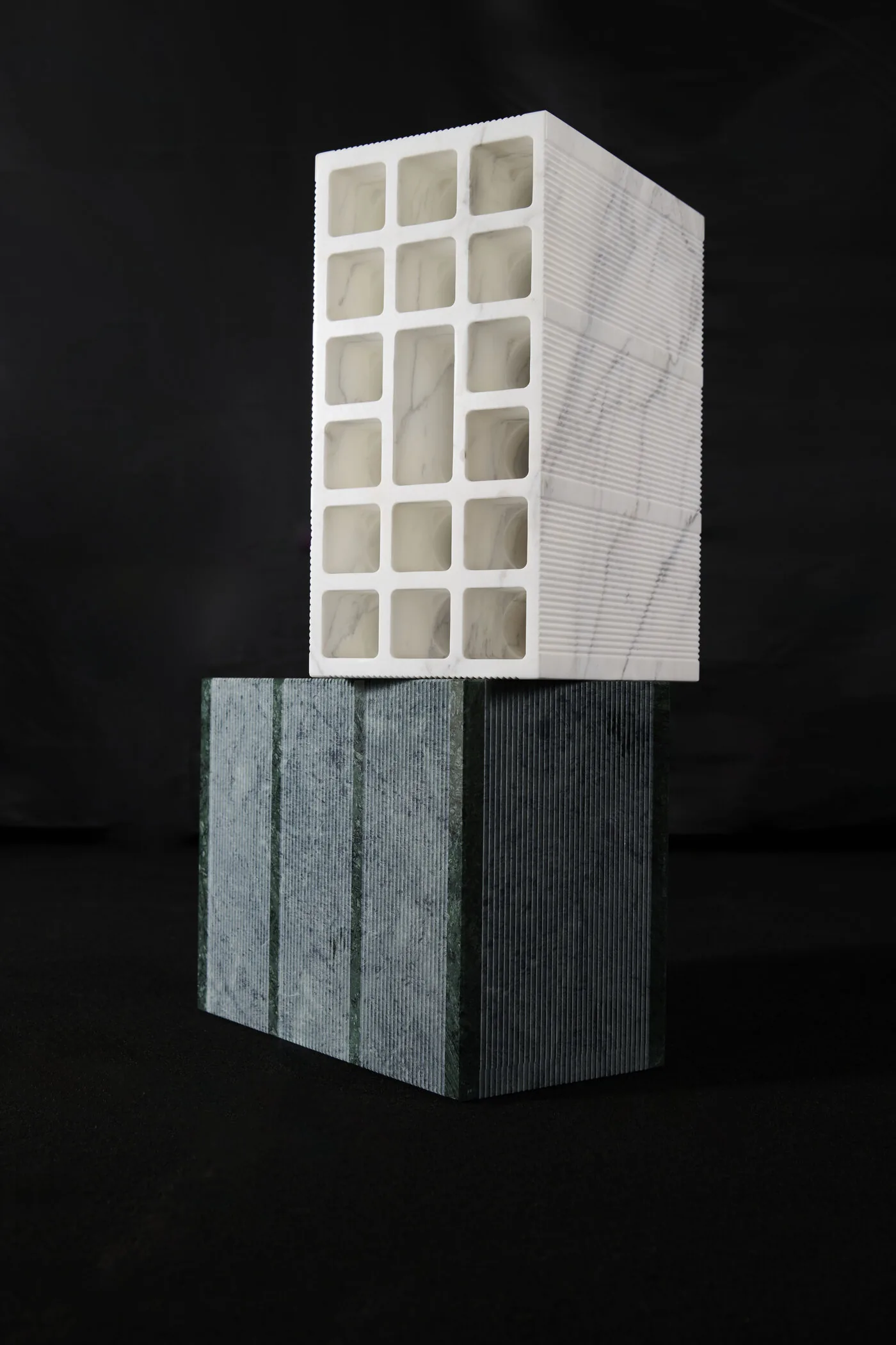 Mattone in marmo bianco di Carrara appoggiato su un mattone in marmo verde