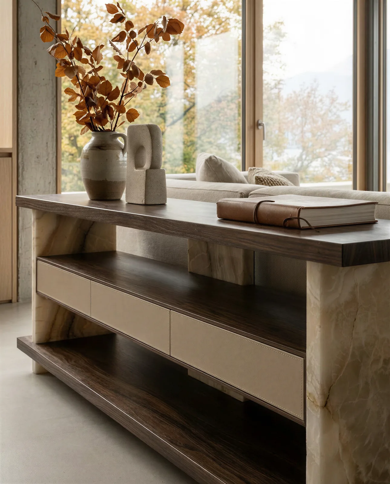La console Oreli di tre quarti, con il piano superiore in noce e i cassetti in pelle